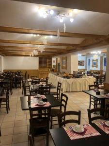 uma sala de jantar com mesas e cadeiras e uma sala com mesas e cadeiras em Soggiorno Dolomiti em Mazzin