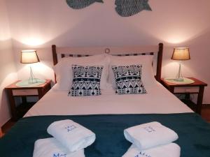 a bedroom with a white bed with pillows and two lamps at Apartamento Mar Azul in Lagos