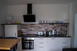 a kitchen with white cabinets and a brick wall at Appartement No 5 in Weimar