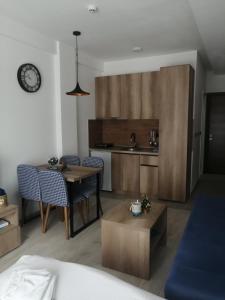 Una sala de estar con una mesa y una cocina. en Apartman Adelfes P16, Milmari Resort, en Kopaonik