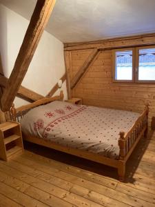 une chambre avec un lit dans une pièce en bois dans l'établissement GITE LE SOLAN DE FINE, à Saint-Jean-de-Belleville