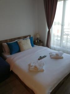 een slaapkamer met een bed met handdoeken en een raam bij Apartman Adelfes P16, Milmari Resort in Kopaonik