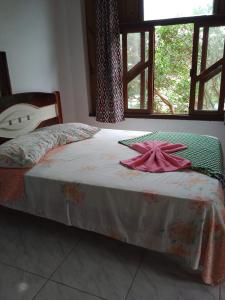 Un dormitorio con una cama con una toalla. en Pousada Revoada dos Papagaios, en Florianópolis
