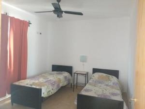 a bedroom with two beds and a ceiling fan at Departamento Triangulo in Santa María