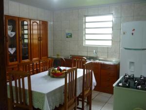 una cocina con una mesa con un bol de fruta. en Casa para aluguel de veraneio em Torres, en Torres