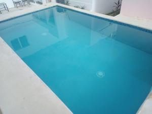 a swimming pool with blue water in a building at Micro Studio perfect for backpackers, couples, 3 min drive to Playa El Nino in Cancún