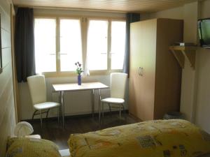 een slaapkamer met een tafel en stoelen en een bed bij Gasthaus Elsigbach in Achseten