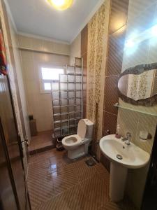 y baño con aseo y lavamanos. en Fully furnished 2 bedroom apartment in new cairo, en El Cairo