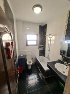 y baño con bañera, aseo y lavamanos. en Fully furnished 2 bedroom apartment in new cairo, en El Cairo