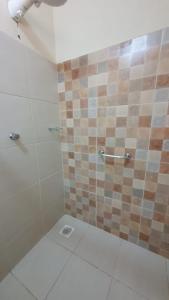 a bathroom with a shower with a tiled wall at Cachoeira dos Luis - Parque & Pousada in Bueno Brandão