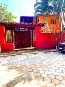 a red building with a car parked in front of it at Pousada Sunset in Itacaré