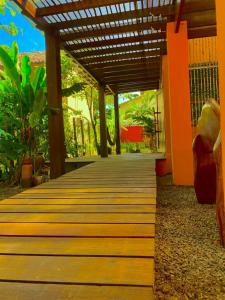 a wooden walkway leading to a house with a wooden roof at Pousada Sunset in Itacaré