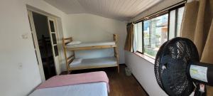 Habitación pequeña con cama y ventana en Hostel Rota do Vale en Blumenau