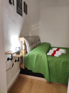 - un lit avec une couette verte dans l'établissement Santa Barbara Apartment, à Catane