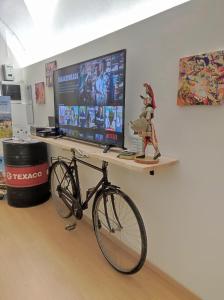 - un vélo sur une étagère dans une chambre avec une télévision dans l'établissement Santa Barbara Apartment, à Catane