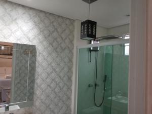 a bathroom with a shower and a glass shower stall at Pousada Jolie Maison in São Francisco do Sul
