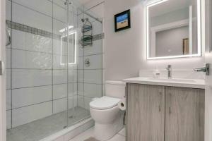 y baño con ducha, aseo y lavamanos. en Rare Find fully renovated 6 bedroom 3 bath and both levels, en Calgary