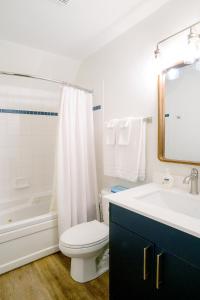 a white bathroom with a toilet and a sink at Loft with a view of Blue - Free Wifi, Linens and Towels Included in Blue Mountains