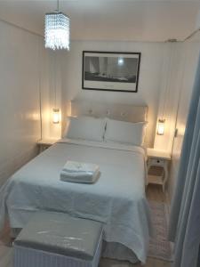 1 dormitorio con 1 cama blanca grande y 2 asientos en Pousada Jolie Maison, en São Francisco do Sul