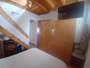 1 dormitorio con 1 cama y TV en un armario en Resiliencia en Río Gallegos