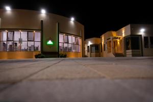 a building with a green light in front of it at AL shoroq Green Resort in Ghubrat Ţanūf