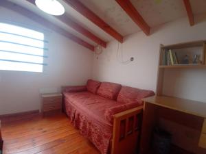 una sala de estar con un sofá rojo en una habitación en Resiliencia en Río Gallegos