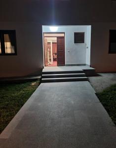 une maison avec une porte et une véranda la nuit dans l'établissement Kuća za odmor Niki, à Pale