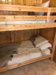 a wooden bunk bed with two pillows on it at Accogliente casa con camino in stile montano in Rovere
