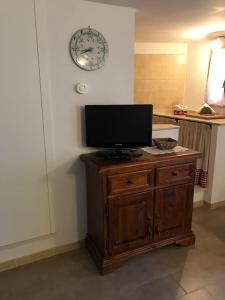a television on top of a wooden cabinet in a kitchen at Accogliente casa con camino in stile montano in Rovere