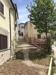 an alley with stairs and a tree next to a building at Accogliente casa con camino in stile montano in Rovere