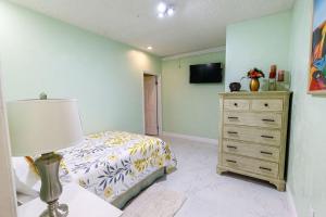 a bedroom with a bed and a dresser and a television at 2 Bedroom Suite in Miami in North Miami Beach