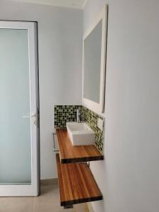 Un baño con un lavabo y un espejo sobre un mostrador. en Casa Gardenia Federación ER, en Federación 20 fotos más