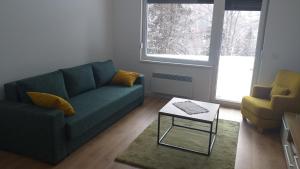 a living room with a couch and a coffee table at Apartmani Šišarka in Kopaonik +33 photos