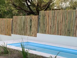 a swimming pool in front of a wooden fence at Casa de Ali in Villa Carlos Paz