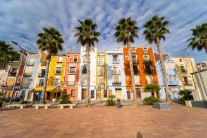 a group of palm trees in front of a building at Villasun palmera beach in Villajoyosa
