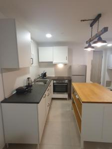 a kitchen with white cabinets and a black counter top at Cosy 35m2 appartment in Zagreb