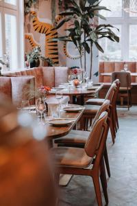 a restaurant with wooden tables and chairs and a tiger wall at Villa la Vida in Tilburg