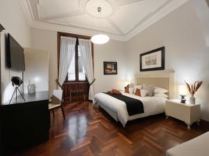 Maison Caesar - Exclusive Apartment [115 m2] في روما: غرفة نوم بسرير كبير وتلفزيون