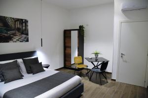 Un dormitorio con una cama y una mesa. en GL rooms and apartments en Bari