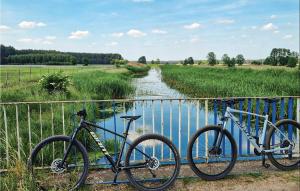 due biciclette parcheggiate su una recinzione accanto a un fiume di 2 Bedroom Beautiful Home In Wilcze a Wilcze