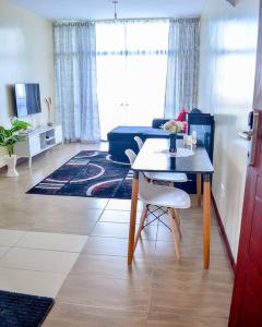 a living room with a table and a couch at Rhezoh Apartment in Nairobi