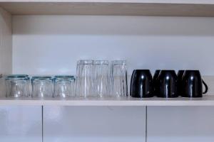 a row of glasses sitting on top of a shelf at Rhezoh Apartment in Nairobi