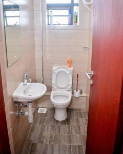 a bathroom with a white toilet and a sink at Rhezoh Apartment in Nairobi