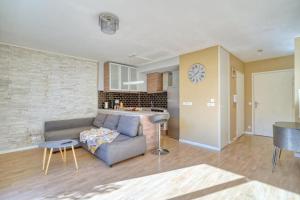 uma sala de estar com um sofá e uma cozinha em Charmant studio avec terrasse et parking em Corbeil-Essonnes