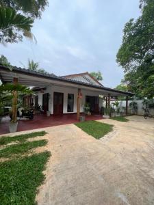 a house with a large driveway in front of it at Jungle Villa in Ahangama