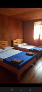 een slaapkamer met 2 bedden met blauwe lakens bij 7th Heaven Lodge and Cafe in Banaue