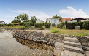 a stone retaining wall next to a body of water at 2 Bedroom Gorgeous Home In Samsø in Toftebjerg
