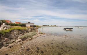 a boat in the water next to a house at 2 Bedroom Gorgeous Home In Samsø in Toftebjerg