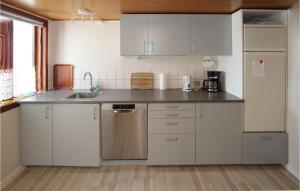 a kitchen with white cabinets and a sink at Nice Home In Sams With 2 Bedrooms And Wifi in Toftebjerg