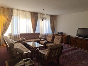 een woonkamer met een bank en stoelen en een tv bij Kuća za odmor Niki in Pale
